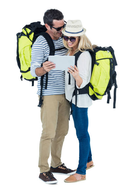 happy couple with luggage looking in digital tablet - travel ipad isolated backpack imagens e fotografias de stock