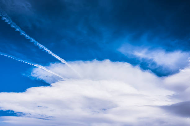 istock Dramatic HDR blue sky with huge fluffy white clouds and jet traces 653217664