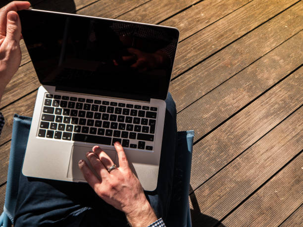 istock Young man working with his laptop on a terrace 653217982