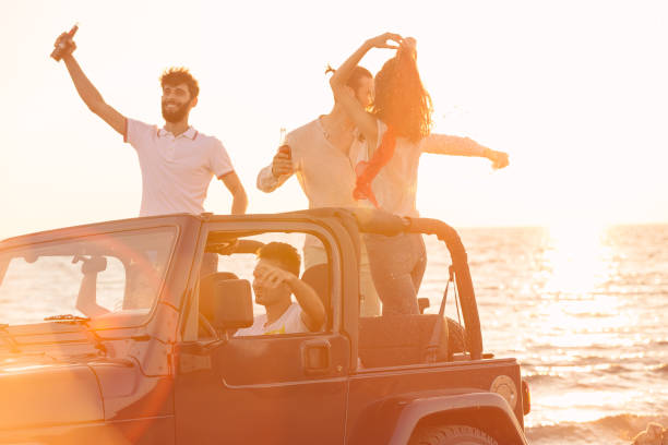 istock Five young people having fun in convertible car at the beach at sunset. 653224608
