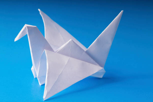istock origami paper crane on blue background 653224986