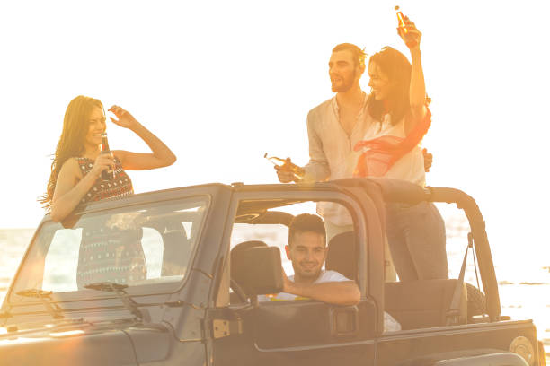 istock Five young people having fun in convertible car at the beach at sunset. 653231248