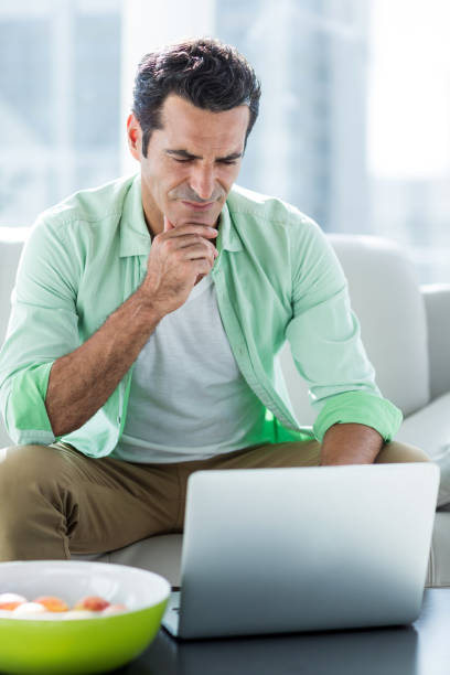 istock Concentrated man using laptop at home 653231760
