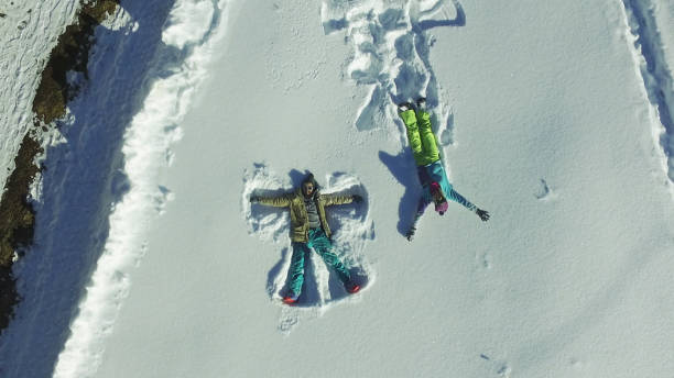 istock Couple making angel silhouette in snow 653245130