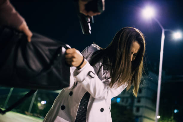 Lady is in danger Two people, man and woman, criminal in action, woman in danger. man holding gun at night in the city stock pictures, royalty-free photos & images