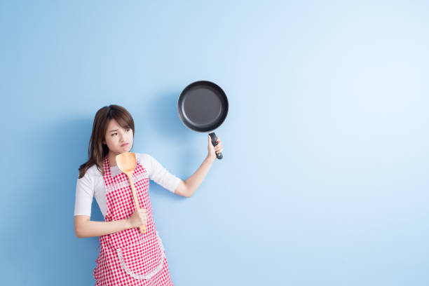 istock housewife take wok and spoon 653264472