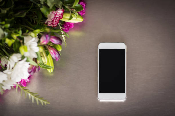 istock Flowers and mobile phone on the table 653264578