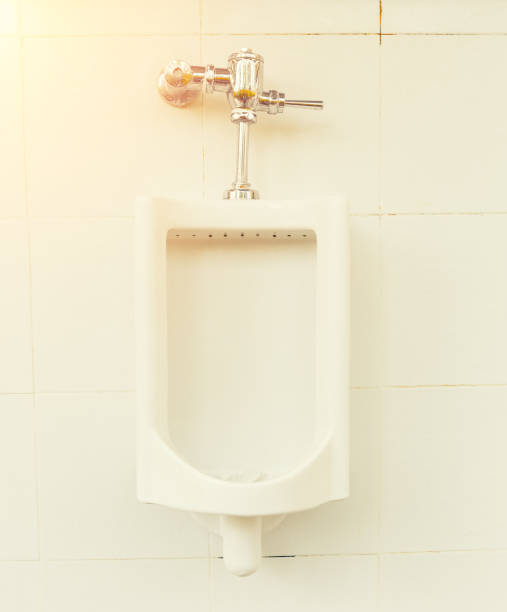 Urinal Tile Wall Row of white urinal for men on tile wall in toilet. flushing valve public restroom toilet stock pictures, royalty-free photos & images