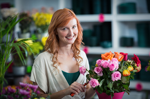 Portrait of female florist preparing flower bouquet in flower shop