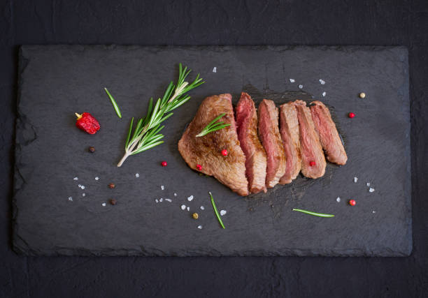 istock Roast beef steak on slate cutting board, top view 653287798