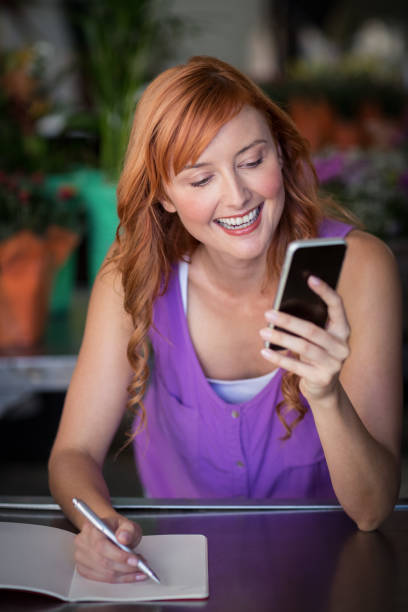 istock Female florist using mobile phone 653288390