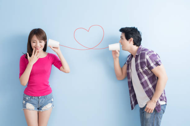 若いカップルが電話することができます。 - whispering couple discussion smiling ストックフォトと画像