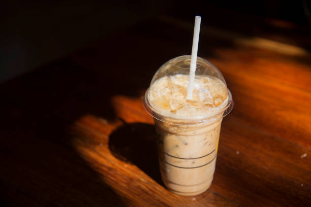 istock Cold coffee in plastic cup on brown wooden table at cafe. 653302946
