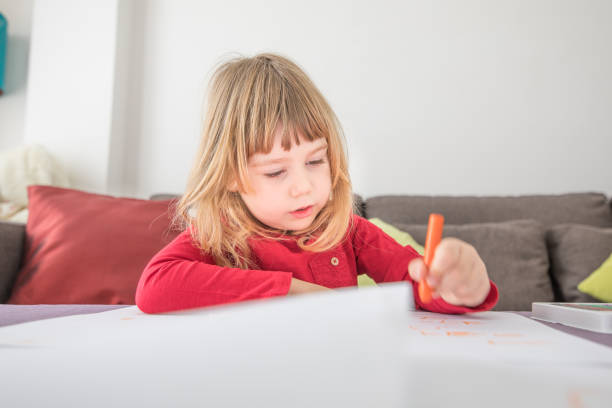 istock blonde child drawing on white paper 653306546