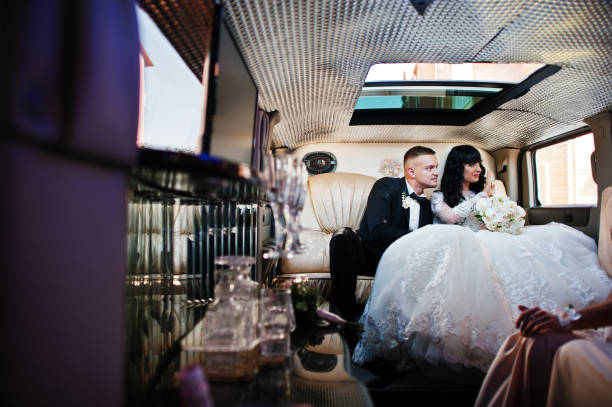 istock Amazing wedding couple inside elegance limousine at their awesome wedding day 653311648