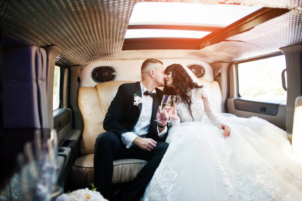 istock Amazing wedding couple inside elegance limousine at their awesome wedding day 653311694