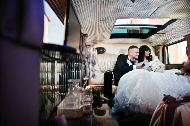 istock Amazing wedding couple inside elegance limousine at their awesome wedding day 653311746
