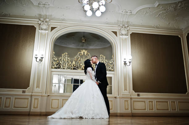 istock Magnificent wedding couple on royal room with many mirrors. 653314836