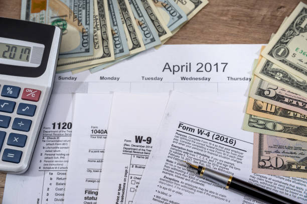 istock w4, w9 tax form with money on desk. 653326242