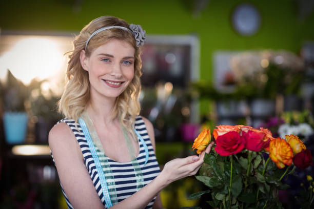 istock Female florist touching rose flowers 653329250