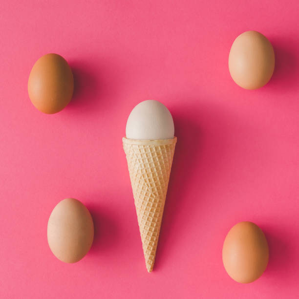 istock Ice cream cone with egg on pink background. Minimal Easter concept. Flat lay. 653329808