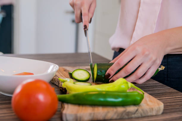 istock Woman slicing vegetables in her kitchen. cutting cucumber 653344722