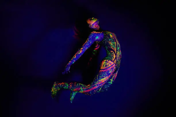 Full length shot of a young woman posing with neon paint on her face