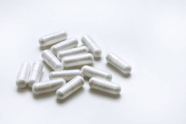 White medicine capsules isolated on white background. stock photo