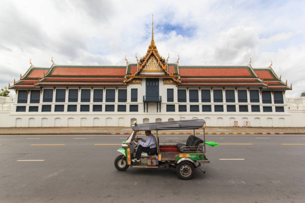 бангкок, таиланд - 21 сентября 2013 г.: традиционный тук-тук на дороге перед знаменитым буддийским храмом ват пхра кау, одной из главных достопр� - bangkok thailand rickshaw grand palace стоковые фото и изображения