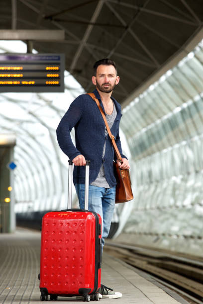 istock Mature man standing on train station platform with bag 653352878