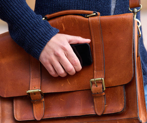 istock Man with leather bad holding mobile phone 653352880