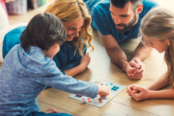 familia jugar juego de mesa en casa - family with two children father clothing smiling fotografías e imágenes de stock