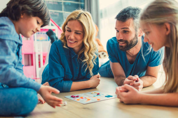 Family Playing Board Game At Home Family With Two Children Playing Board Game on The Floor At Home.*game table designed by vgajic board game stock pictures, royalty-free photos & images