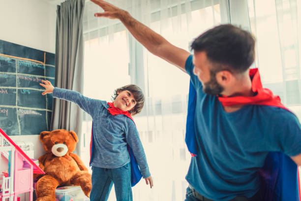 istock Father and son with capes at home 653364814