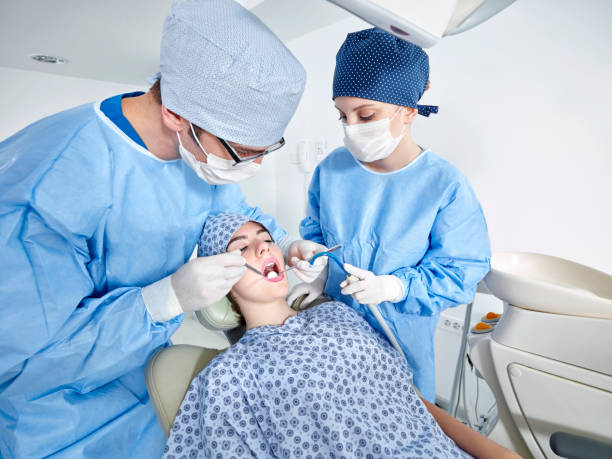 istock Dentist and assistant examining girl's teeth X-ray 653371708