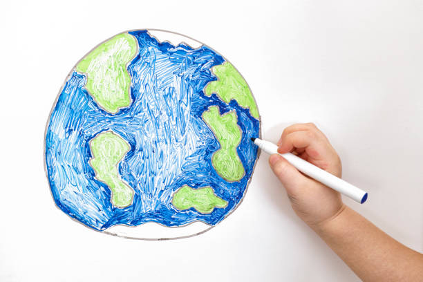 istock Child's hand drawing planet Earth with a marker 653375088