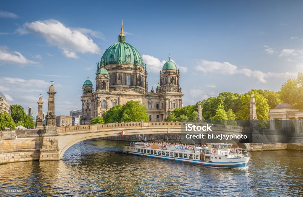 Berlin Cathedral with ship on Spree river at sunset, Berlin, Germany Beautiful view of historic Berlin Cathedral (Berliner Dom) at famous Museum Island with ship passing Friedrichsbrucke bridge on Spree river in golden evening light at sunset in summer, Berlin, Germany Berlin Stock Photo