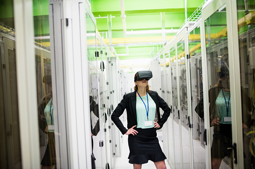 Technician using virtual reality headset in server room