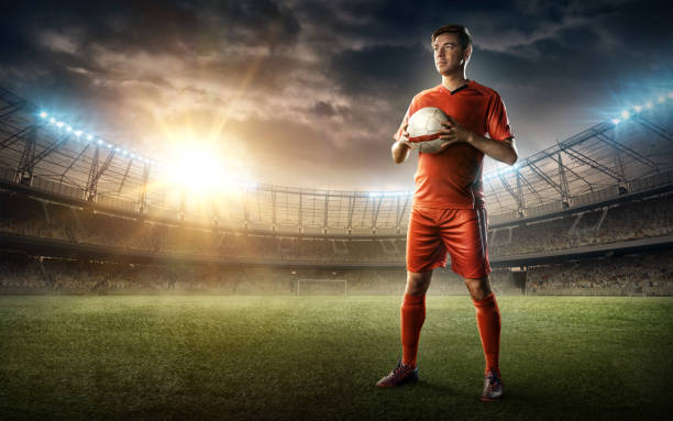 istock soccer player in red uniform with a ball 653382636