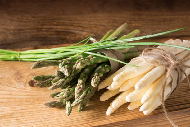 istock Bunch of asparagus with chives on wood 653387932