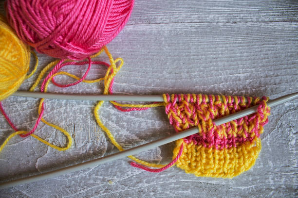 istock knitting needles and a colorful thread on the wooden table 653390344