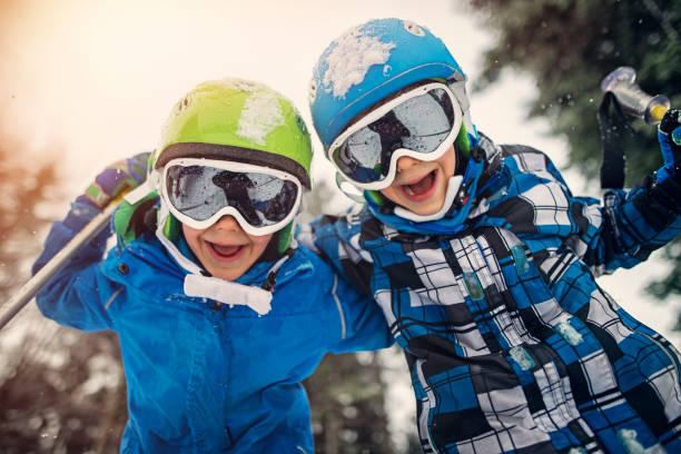 retrato de pequenos esquiadores rindo para a câmera - skiing snow skiing helmet fun - fotografias e filmes do acervo