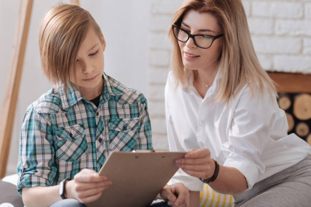 istock Positive expert sitting near young patient 653394954
