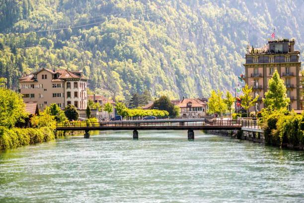 Interlaken, Switzerland - May 5, 2014: Interlaken streets with shops, cafes and hotels. People and cars on the streets.