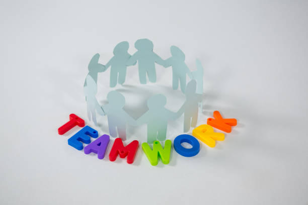 istock Circle of paper cut-out figures with teamwork word 653402456