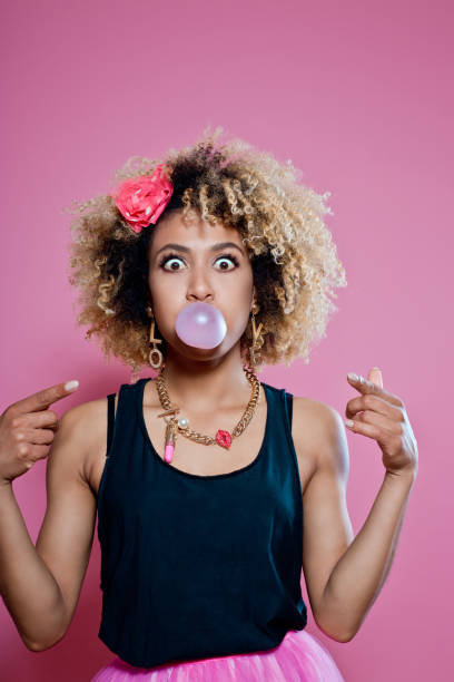 istock Cute afro woman blowing bubble gum 653416868