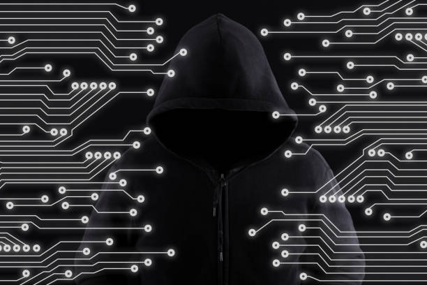 Hacker with a hood on black with binary codes on background. stock photo
