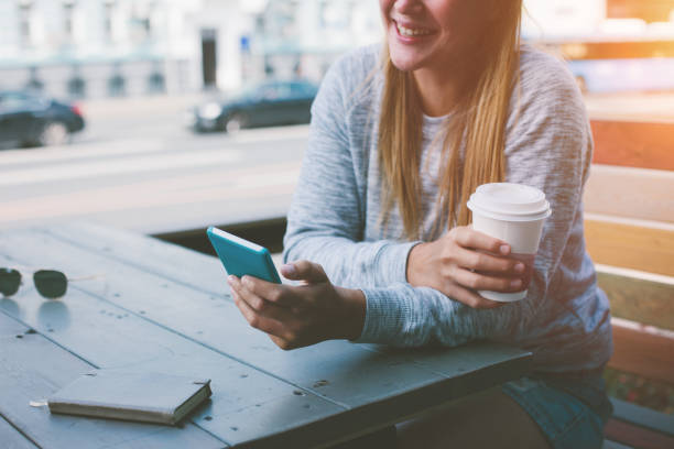 istock Young woman with mobile phone in cafe 653420306