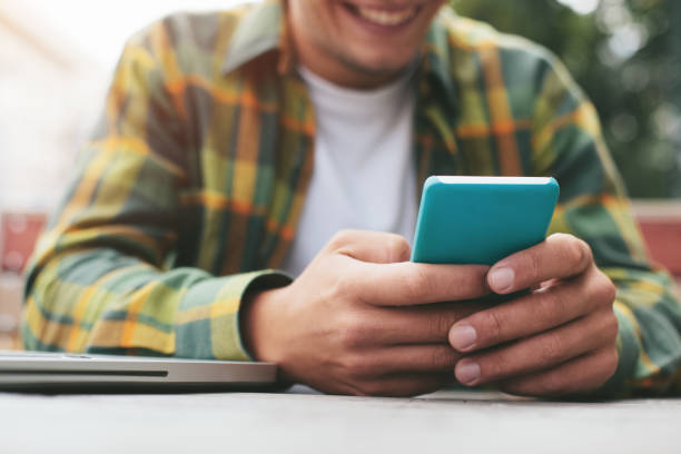istock Man with mobile phone sitting in street cafe 653423574