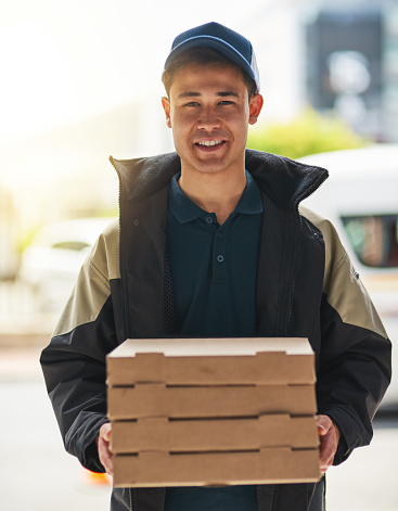 Portrait of a young man making a pizza delivery